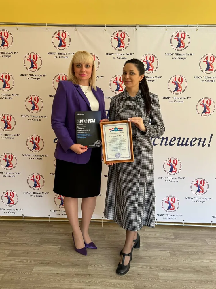 Кристина Баховка с представителем школы № 49, в руках сертификат и благодарность